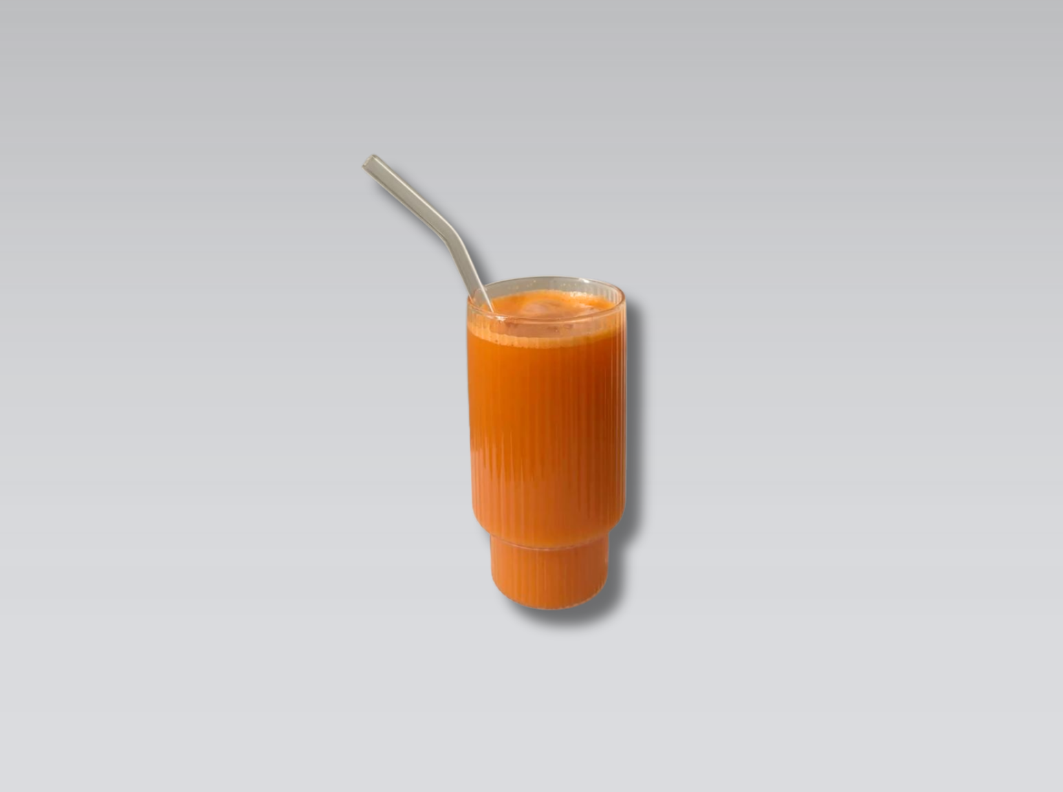 Glas mit orangem Karottensaft und Kokoswasser – der virale TikTok Skincare Drink